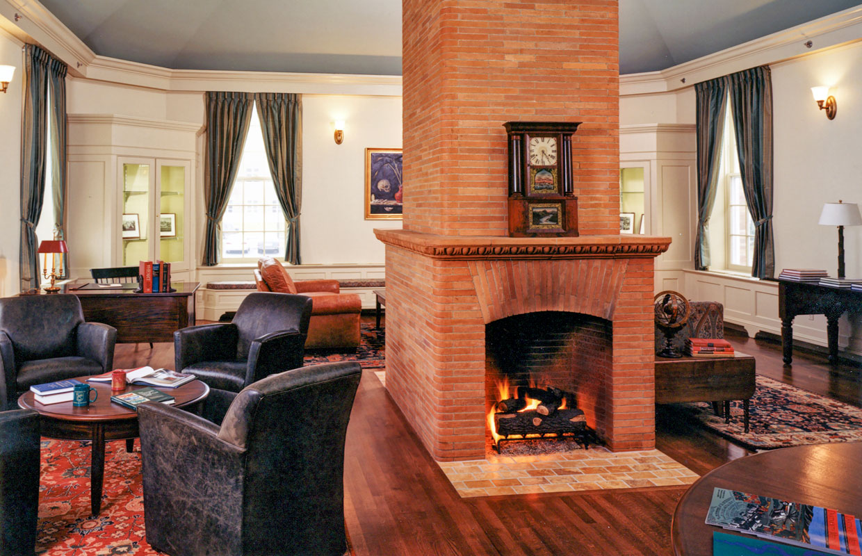 large room with a central fire place and tables around the outside