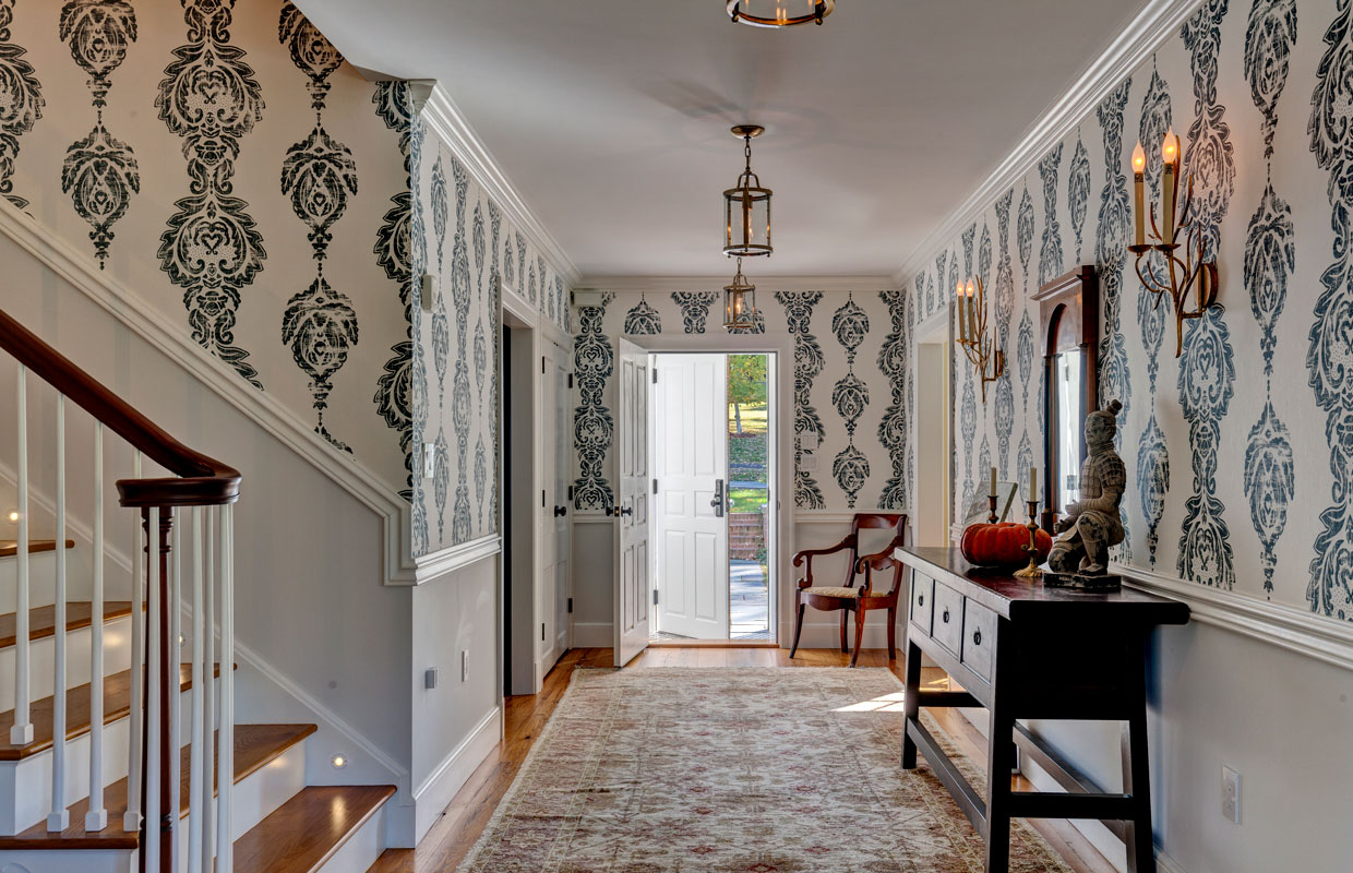 view of a front door from inside across an entry way with a staircase to the left