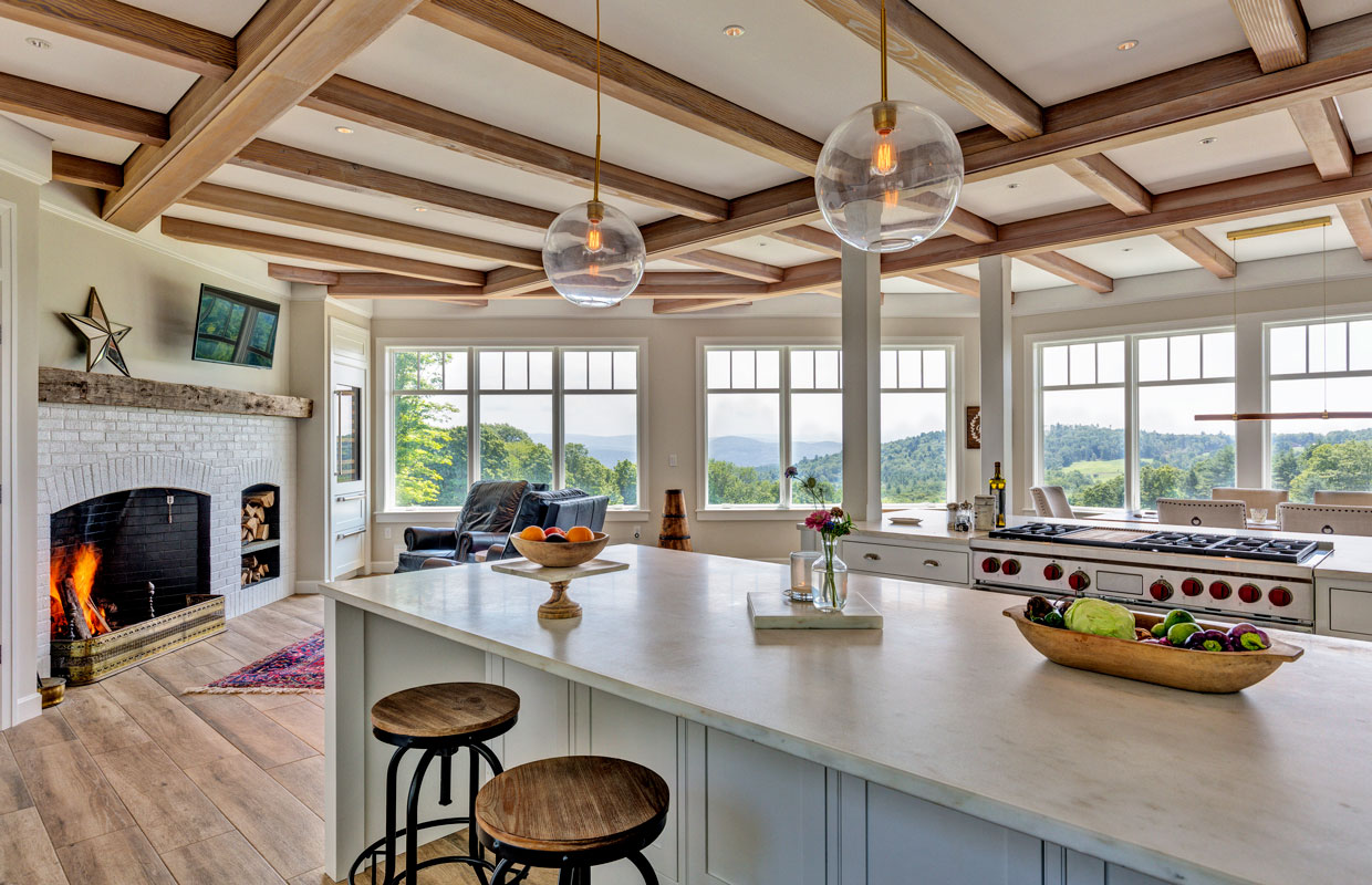 large kitchen with wrap around windows, exposed beams and a fireplace