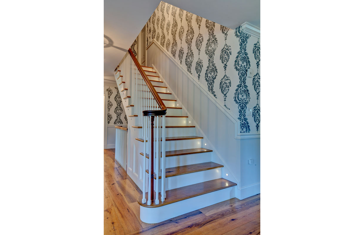 wooden stair case with blue and white wallpaper
