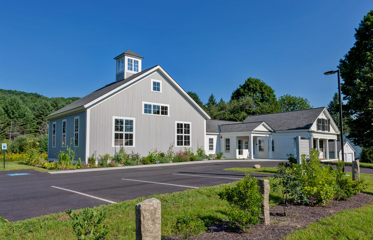 gray meeting house and tar parking lot