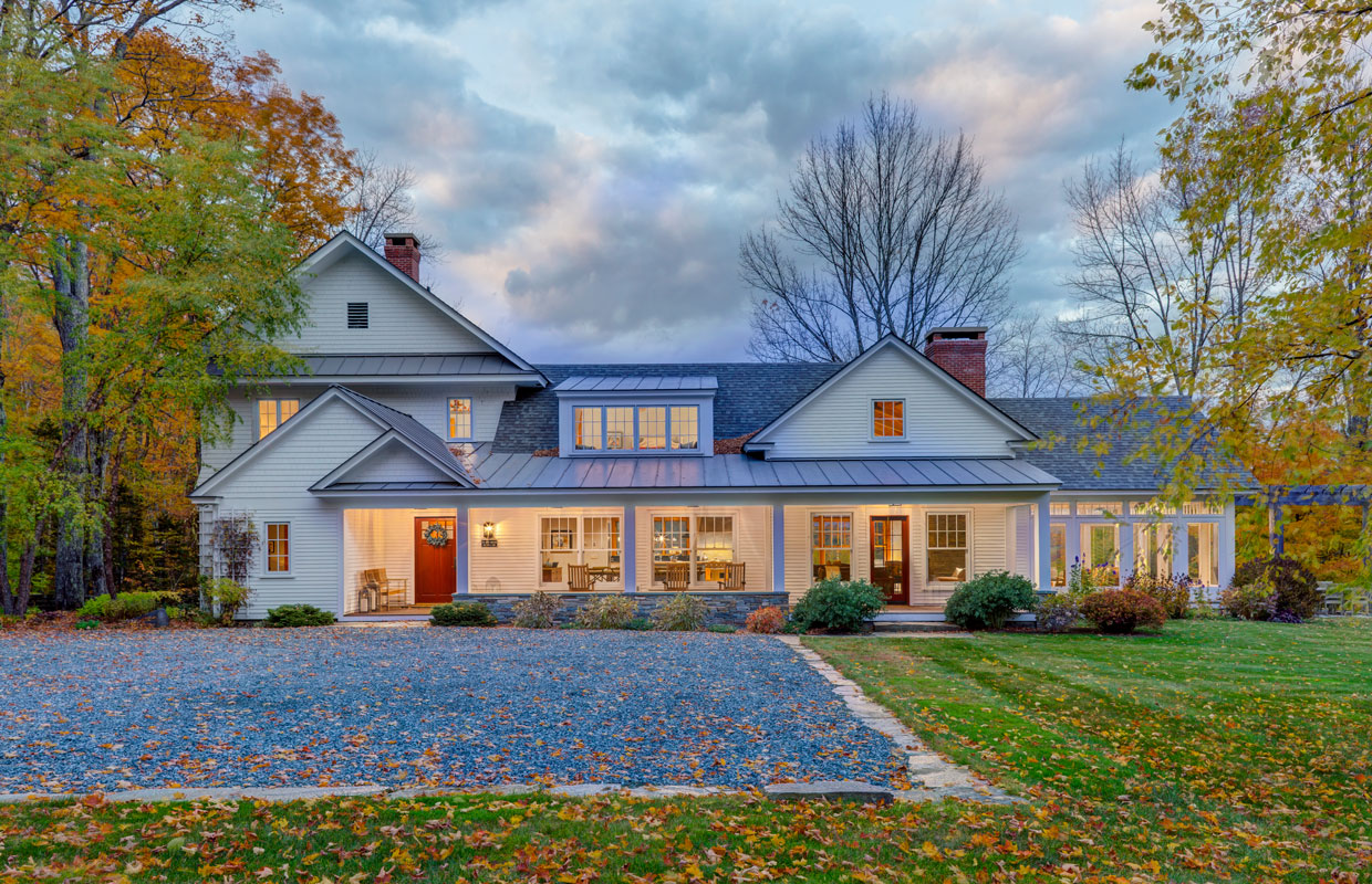 large white house with lots of windows and a stone driveway