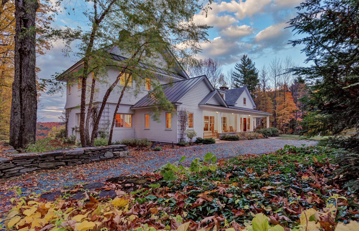 large white house in the fall with a stone driveway