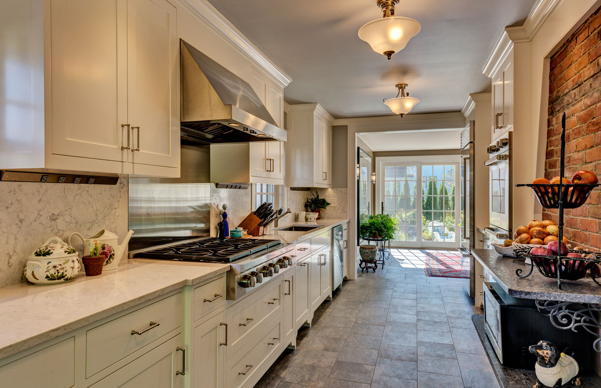 view down a kitchen counter of a large stove top and big window in the background