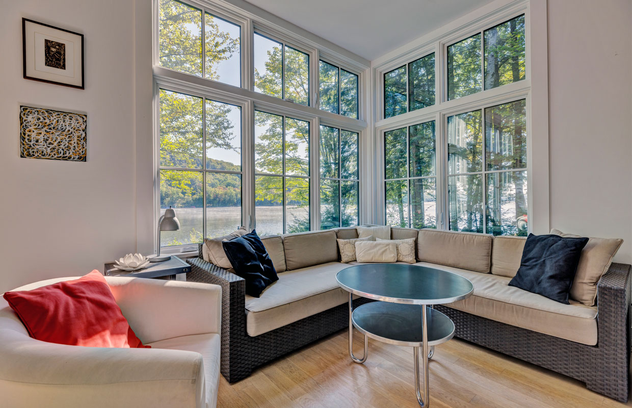 sitting room with lots of windows and a wrap around couch