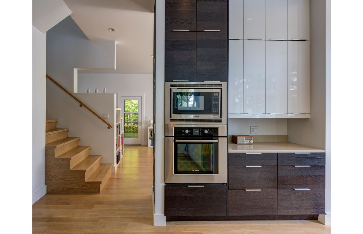 kitchen oven on the wall with the stairs to upstairs to the left