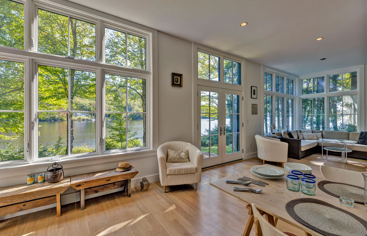 large room with a full wall of windows and lush green outside