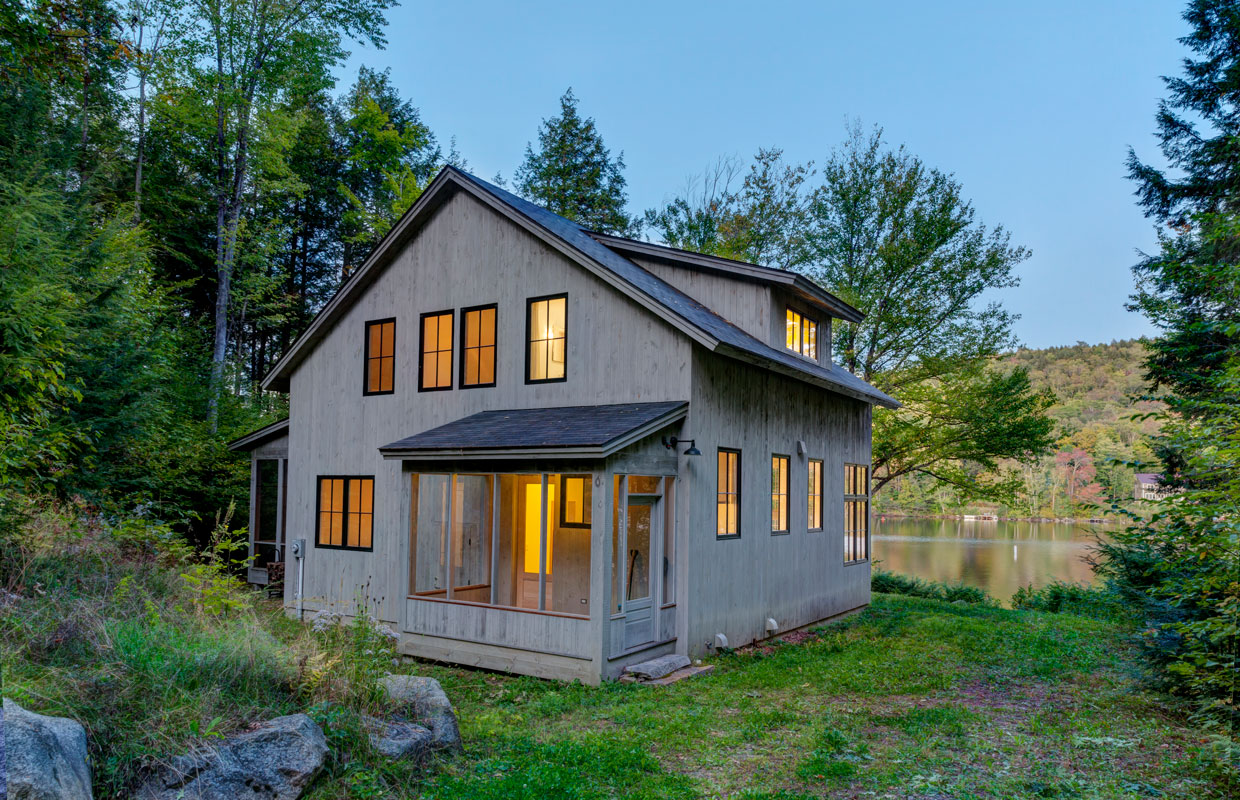 cottage at dusk with lights on inside