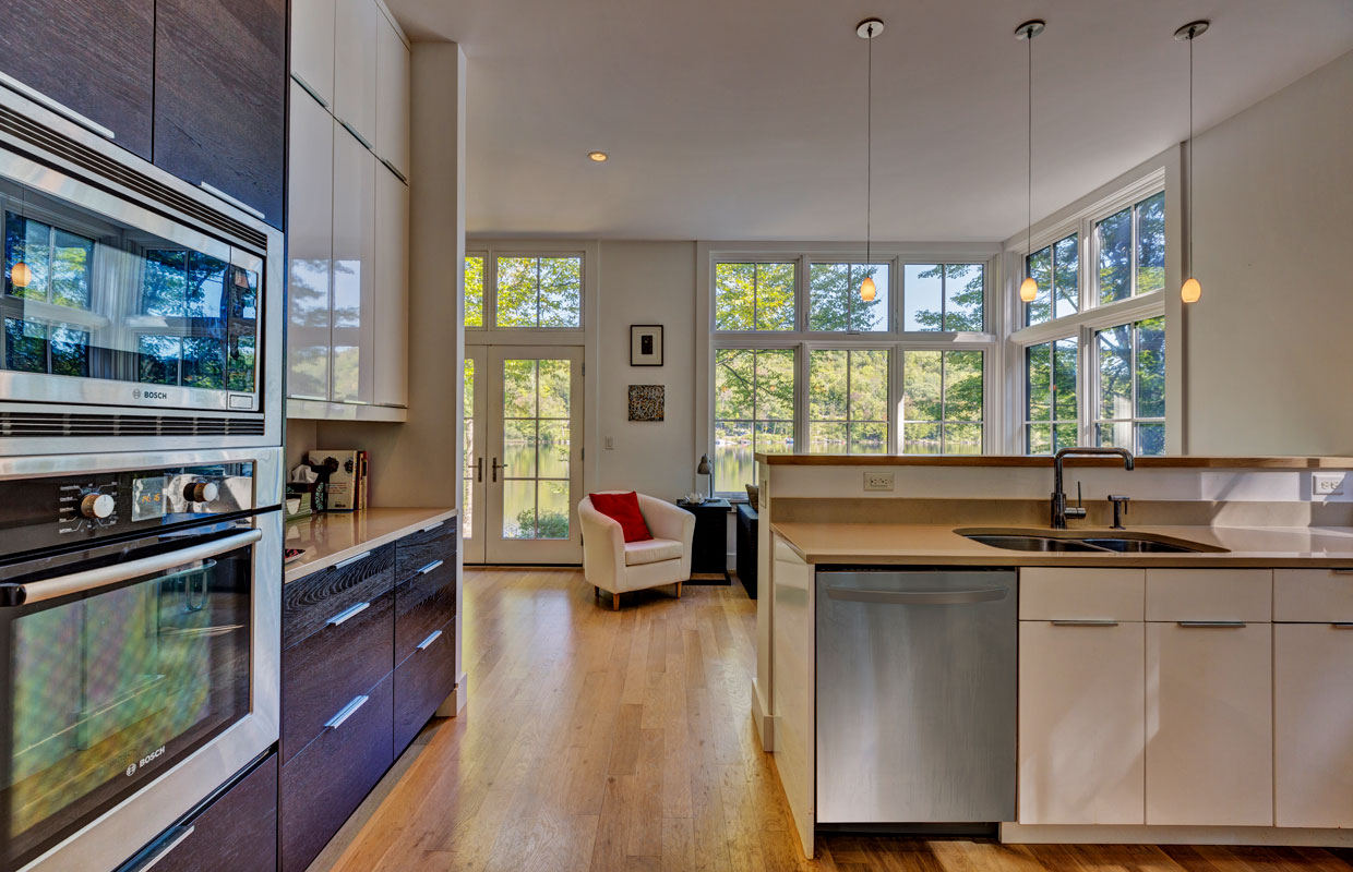 view from a kitchen into the next room lot of windows in the background