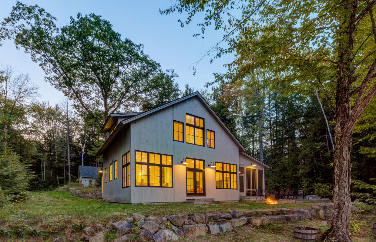 cottage at dusk with lights on inside