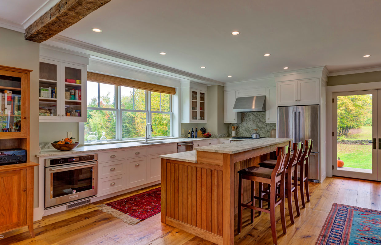 view of a large kitchen with island and tall chairs