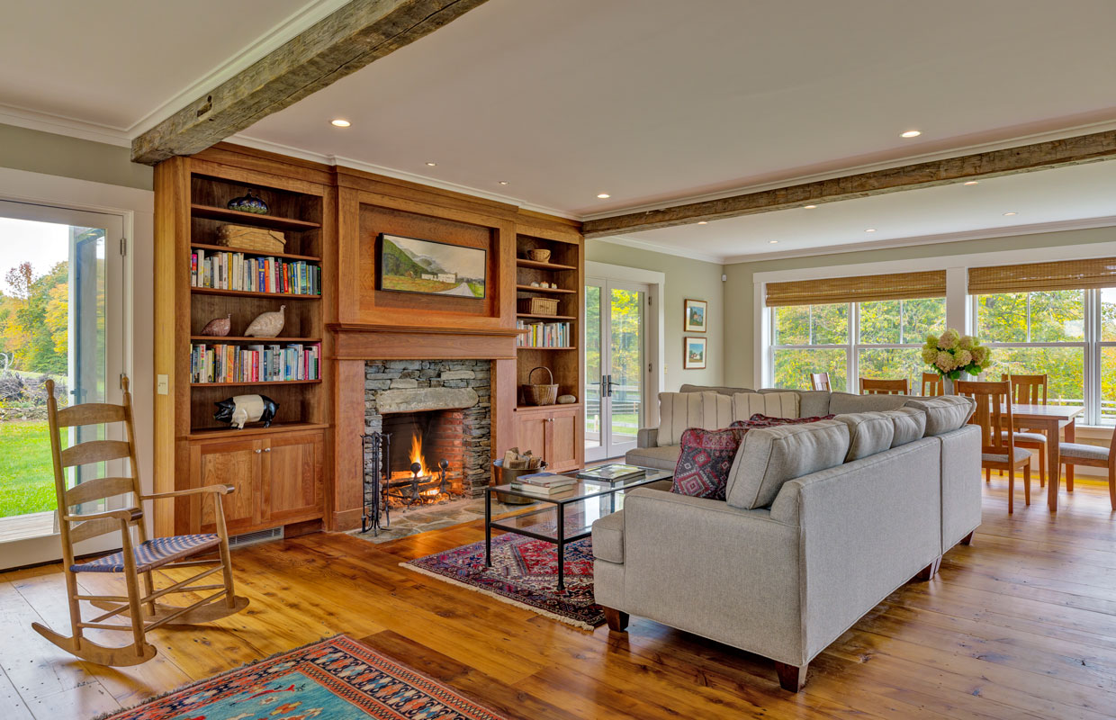 living room with fireplace and large gray couch and a wooden rocking chair