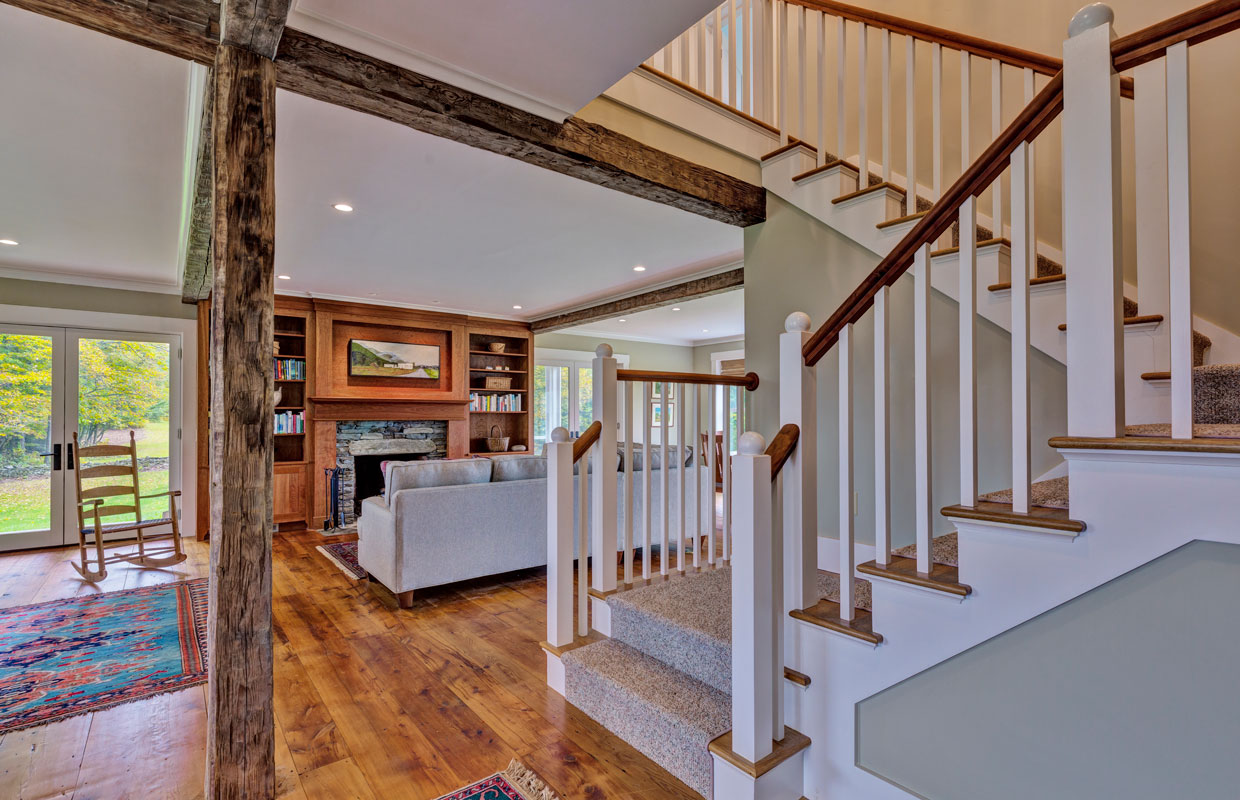 white wooden staircase and view of the living room in the background