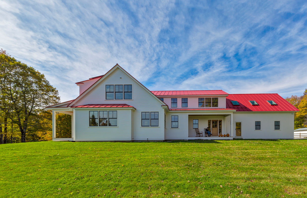 large white house with a red roof and blue sky