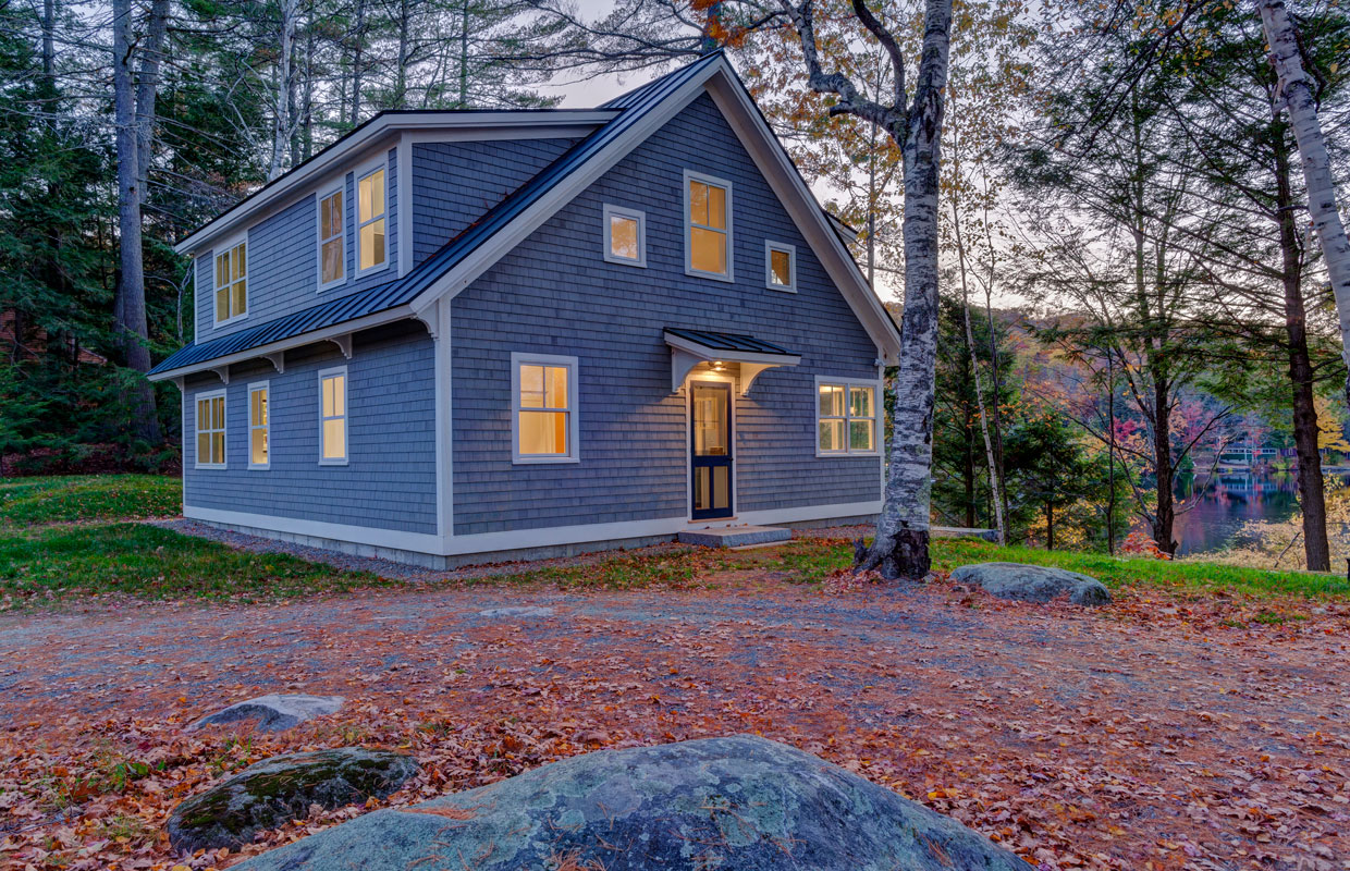 gray cottage view from the driveway with autumn leaves