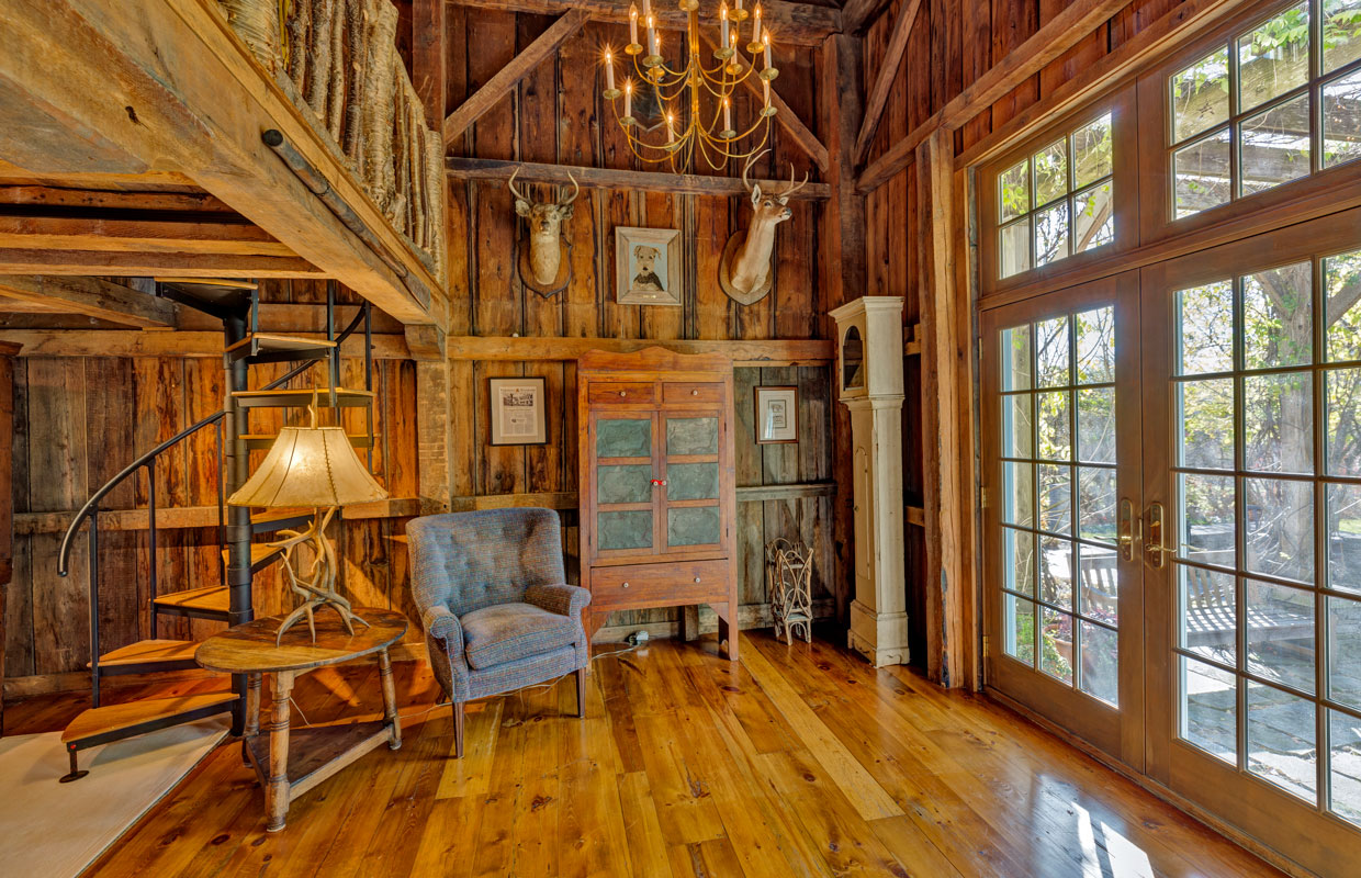 natural wood room with deer mounts on the wall and a spiral staircase