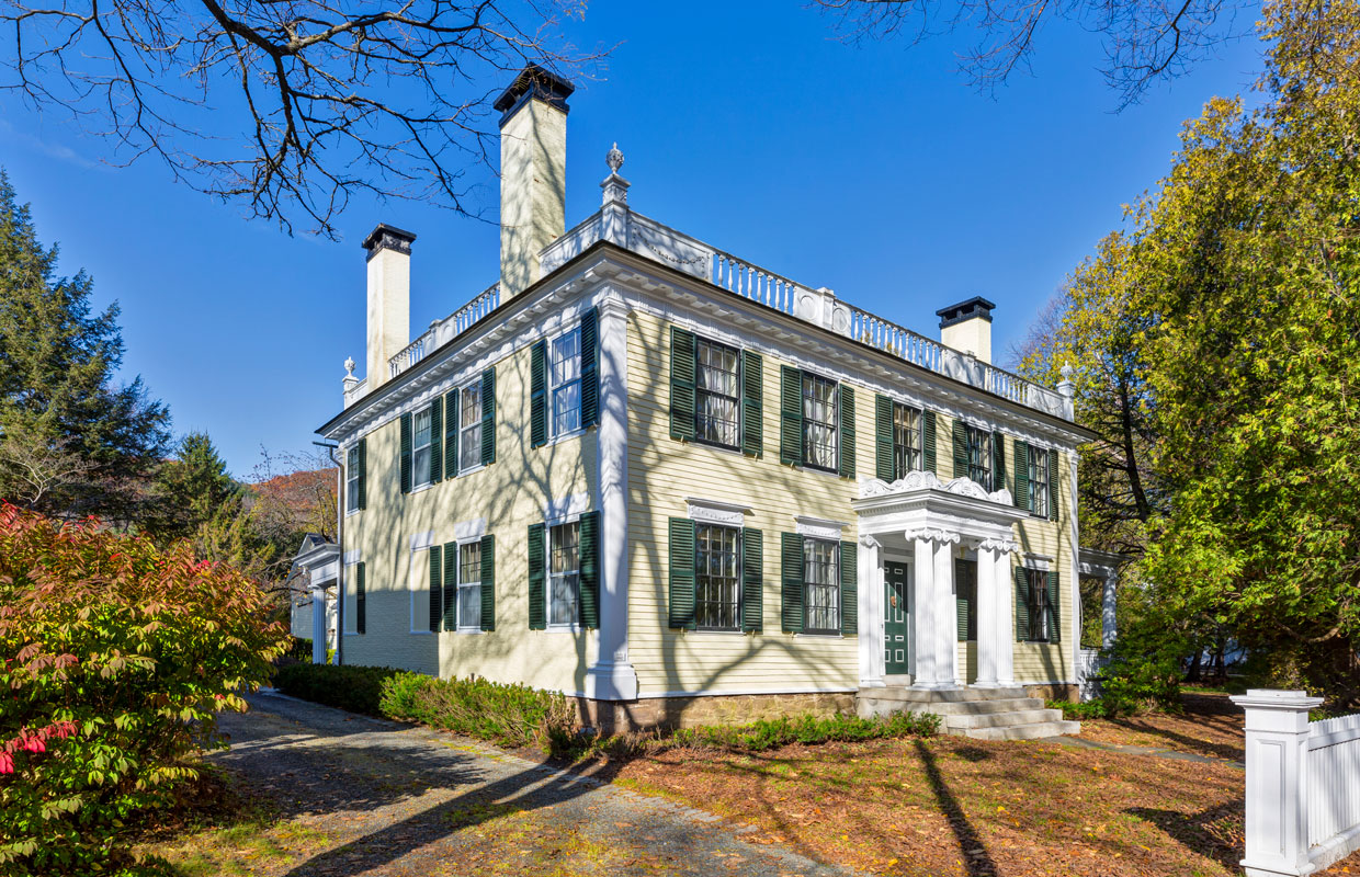 large yellow house with multiple chimneys
