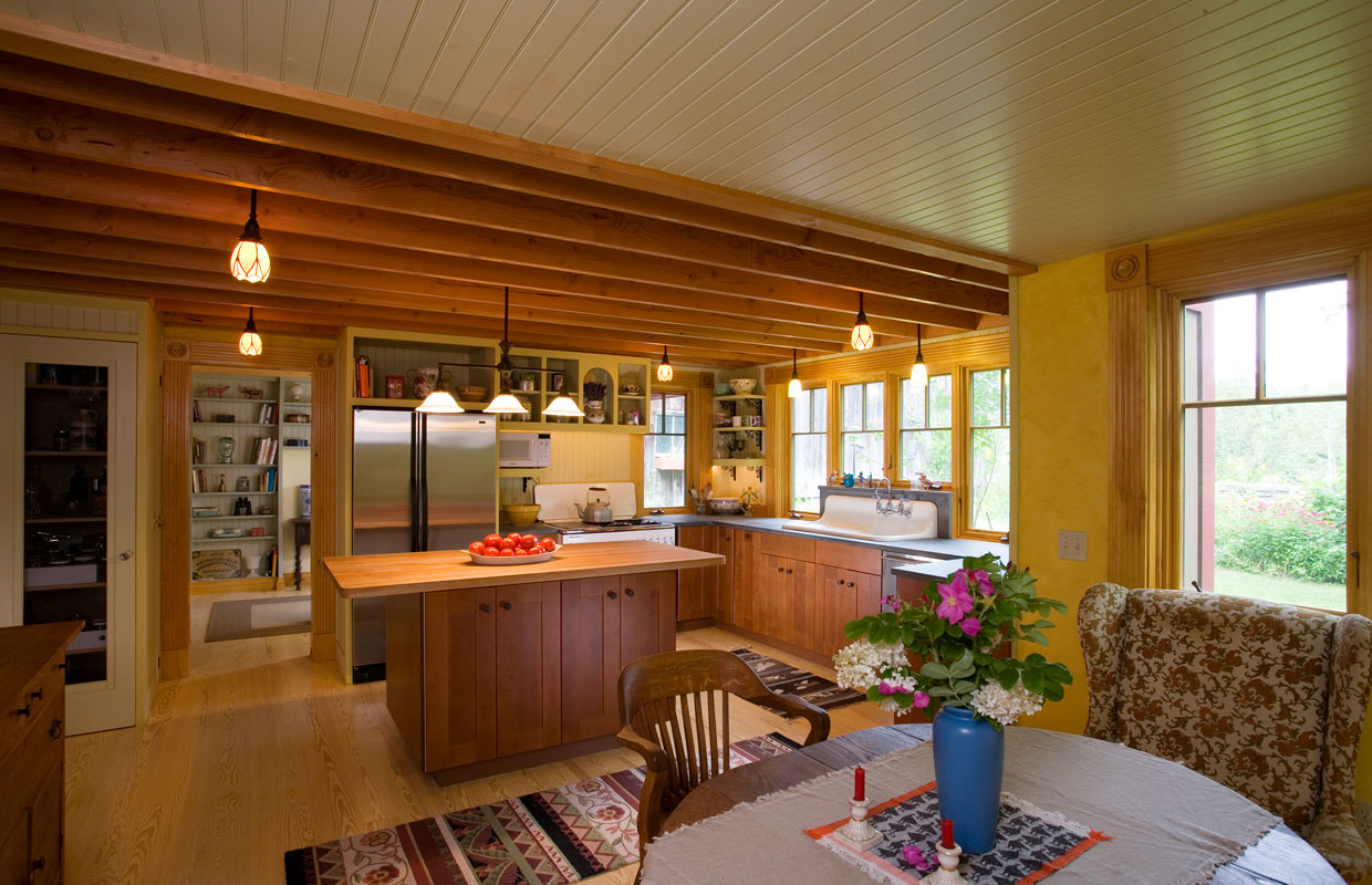view into a kitchen from the dining room with lots of wood accents and natural light