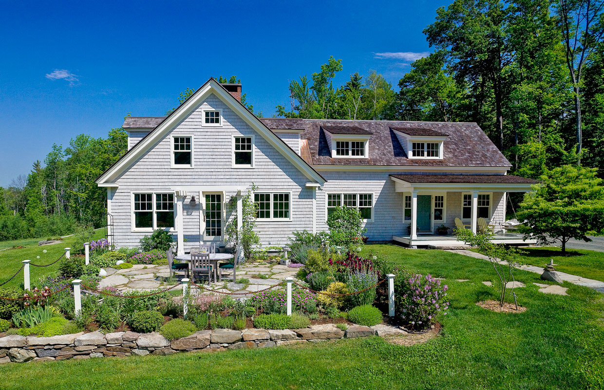 gray house with lush green lawn