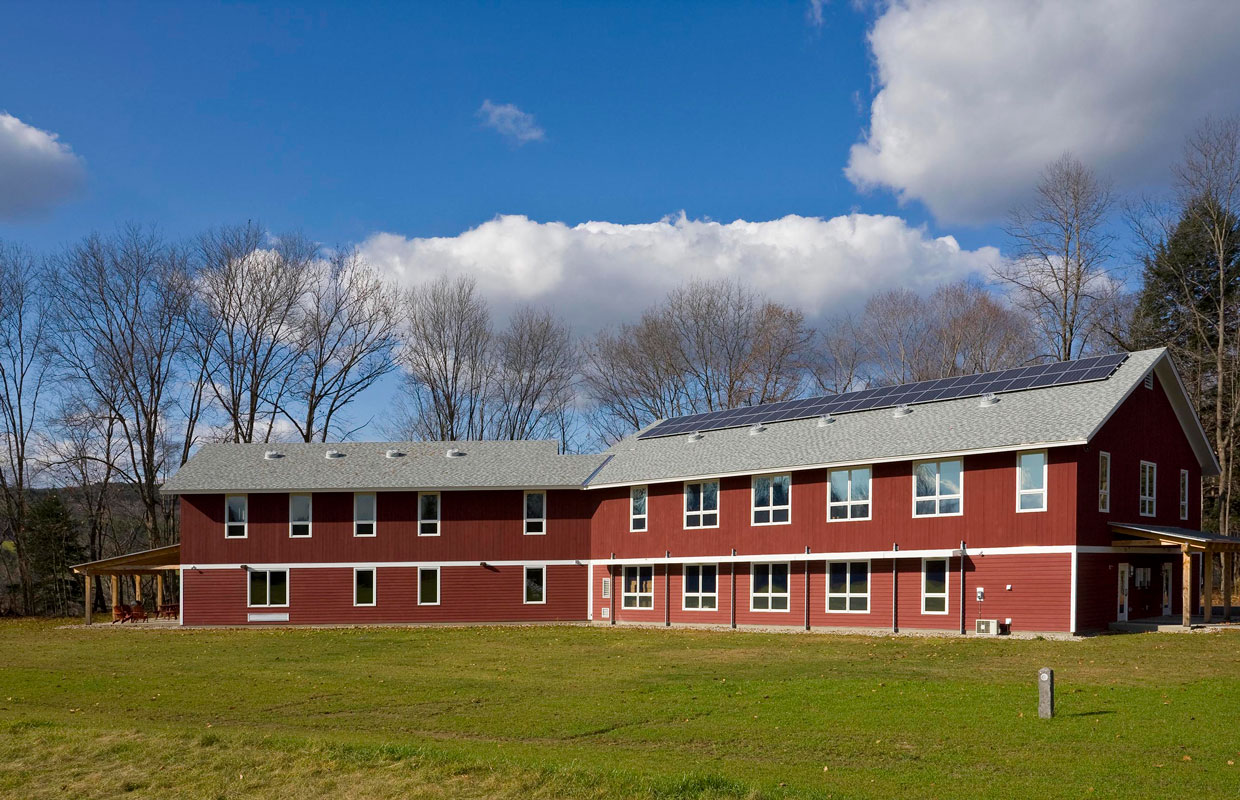 large red barn-style building with solar panels on the roof