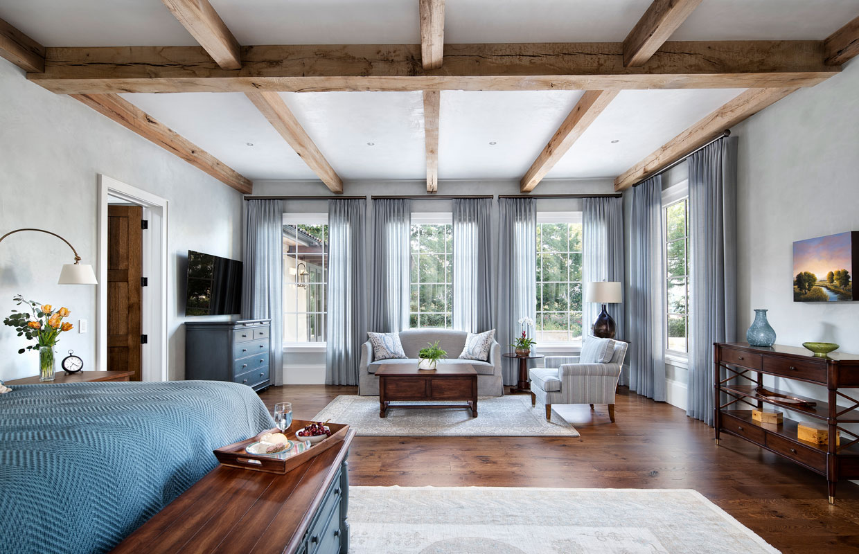 bedroom with exposed beams and large seating area