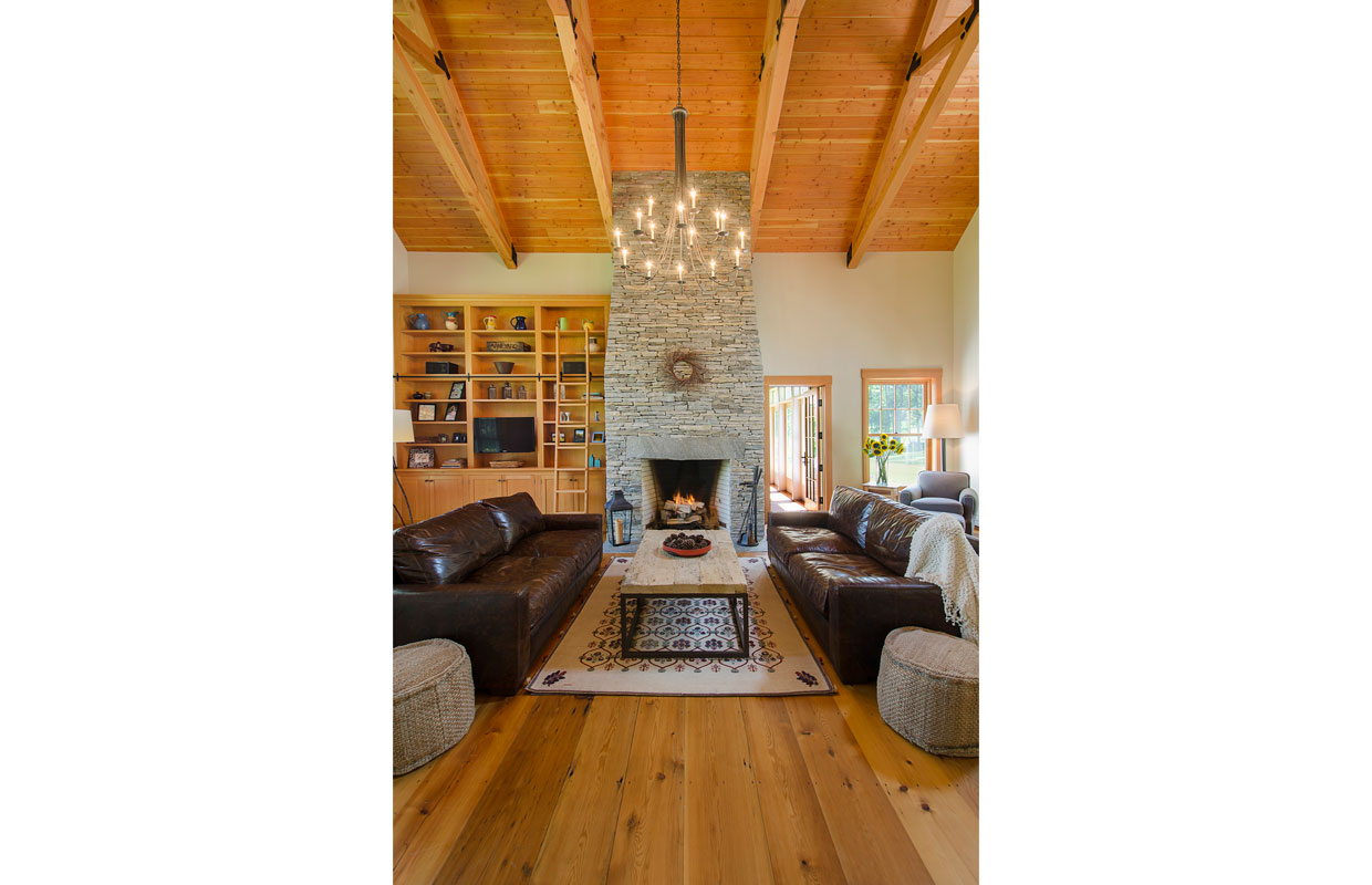 great room with wood ceilings and a stone fireplace