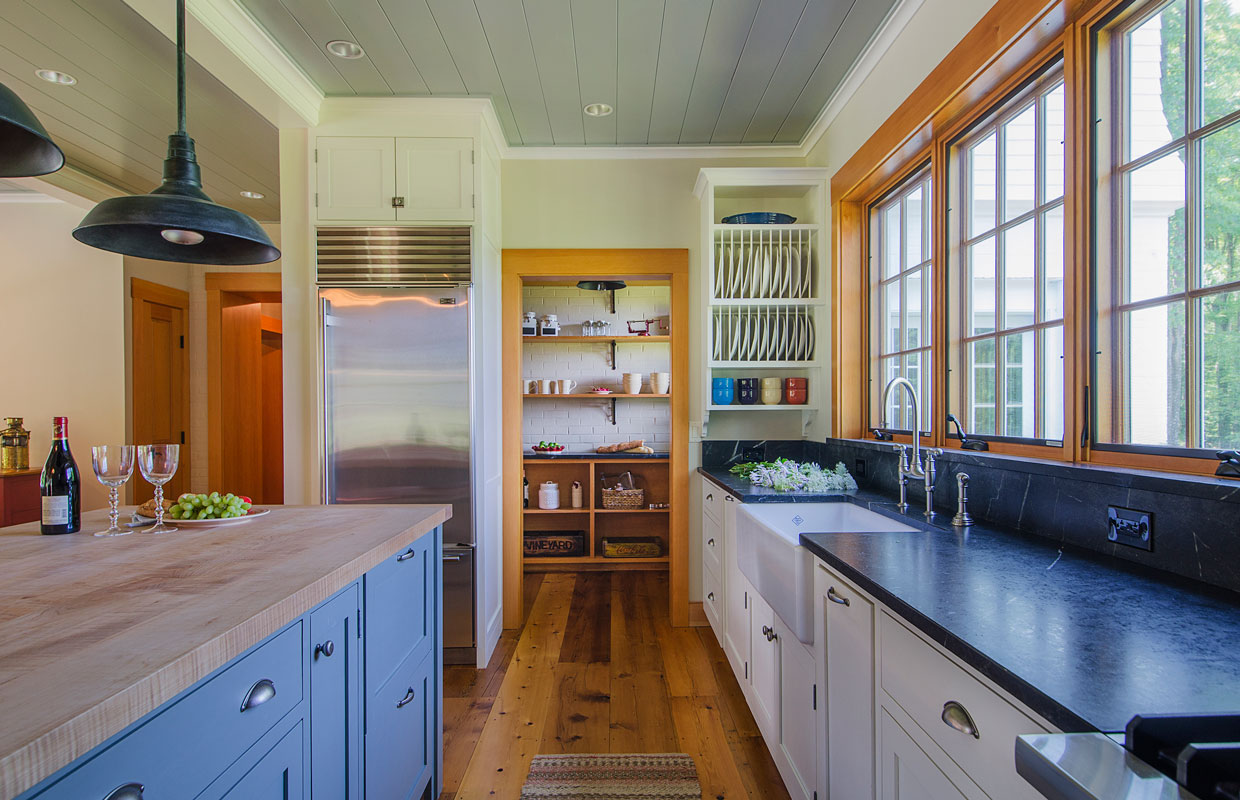 large kitchen with stone countertops and a wood island