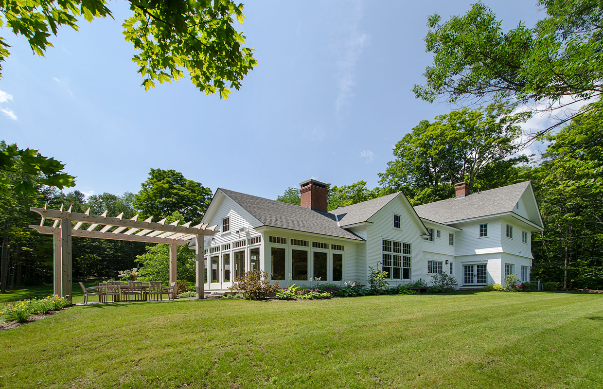 large white house with a pergola and green grass