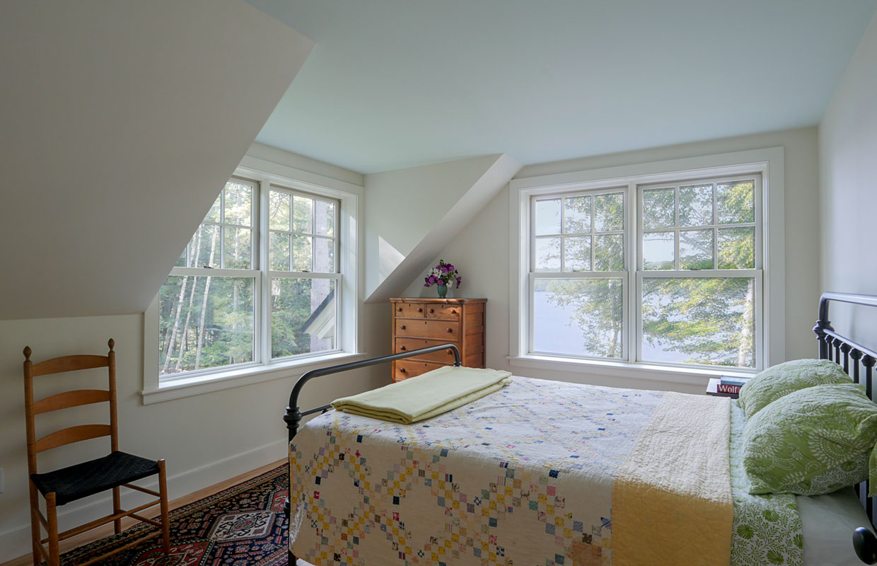 bedroom with slanted ceilings and while walls