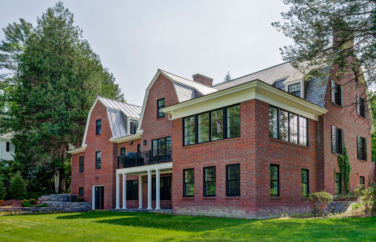 large brick house with green grass out front