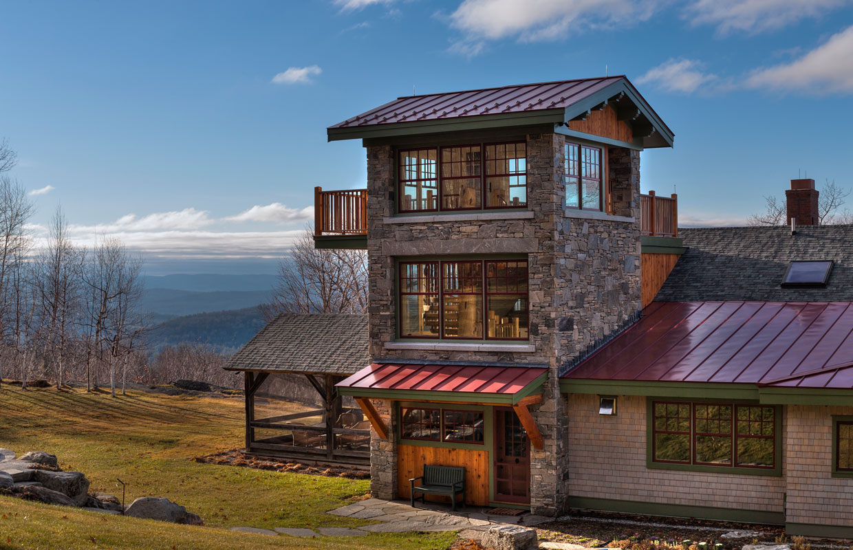 stone tower with a suspended deck on a home with a mountain view in the background