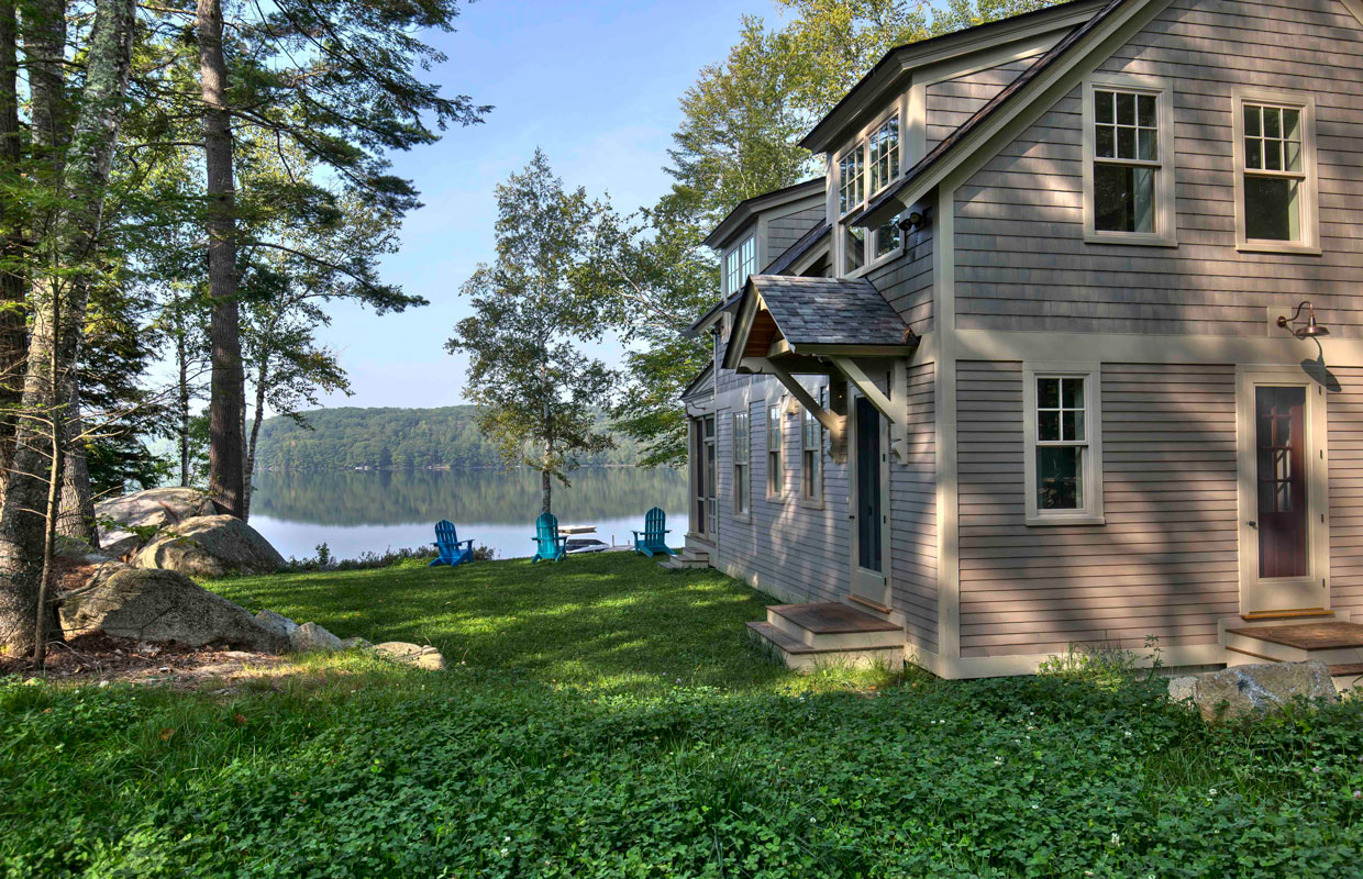 tan house on a lake view from the yard looking at the lake with the house to the right