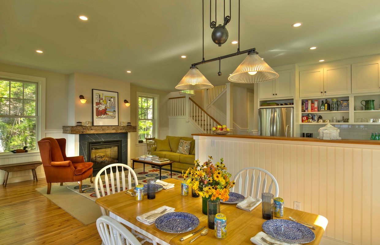 view of a living room and staircase in the background with a red chair and fireplace