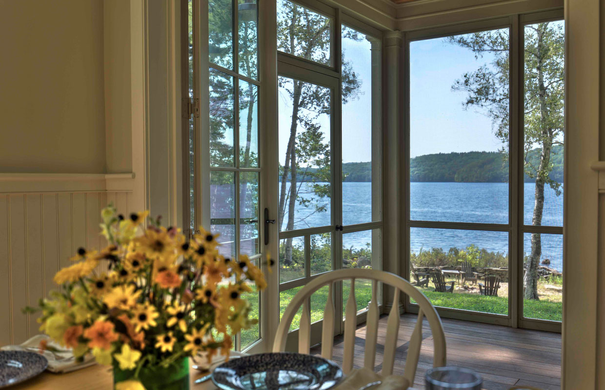 view of a lake outside from inside a screened in area