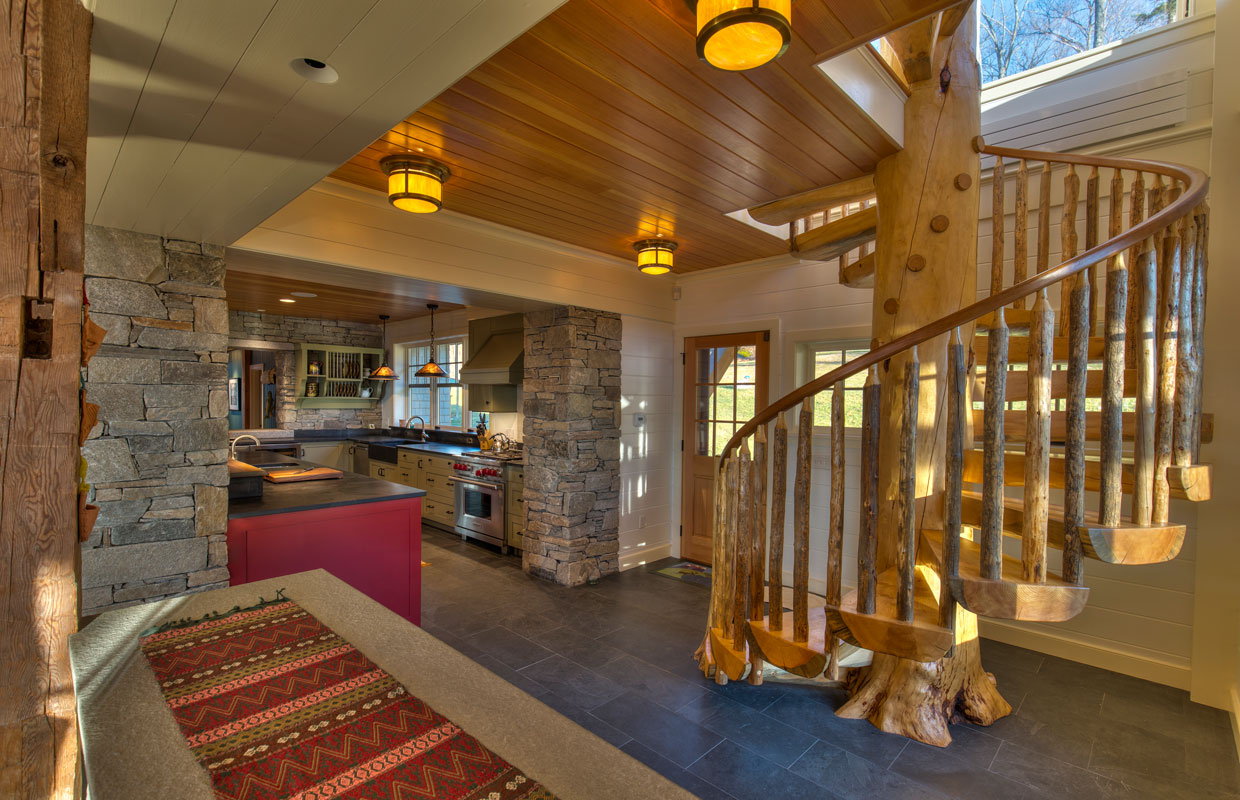 natural wood spiral staircase with a view into a great room