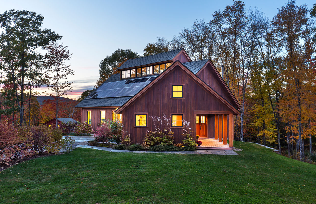 barn at dusk with solar panels and green grass
