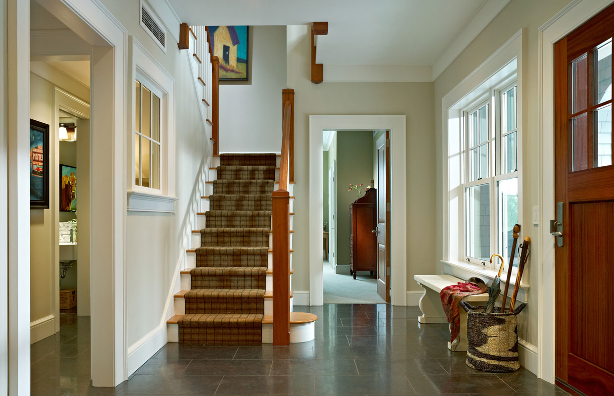 staircase from downstairs looking up with the front door to the right