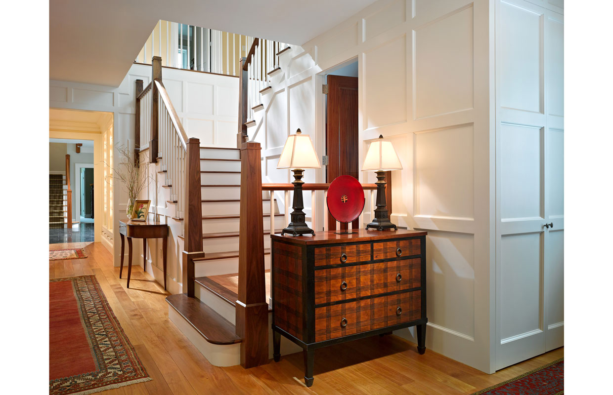 wooden dresser at the bottom of a staircase