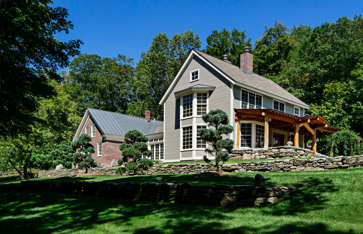 gray and brick house with a stone wall view from outside